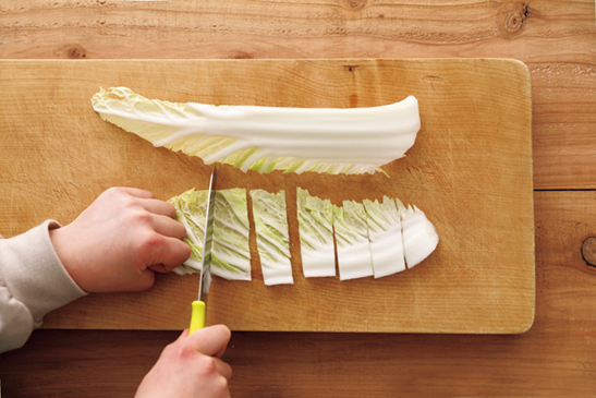 包丁で白菜を切る子どもの手もと