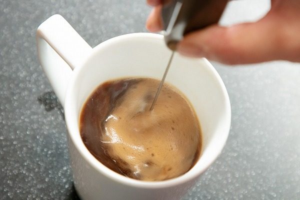 コストコ　SPORTS RESERCH オーガニックMCTオイル 1183ml を加えたコーヒーを攪拌しているところ
