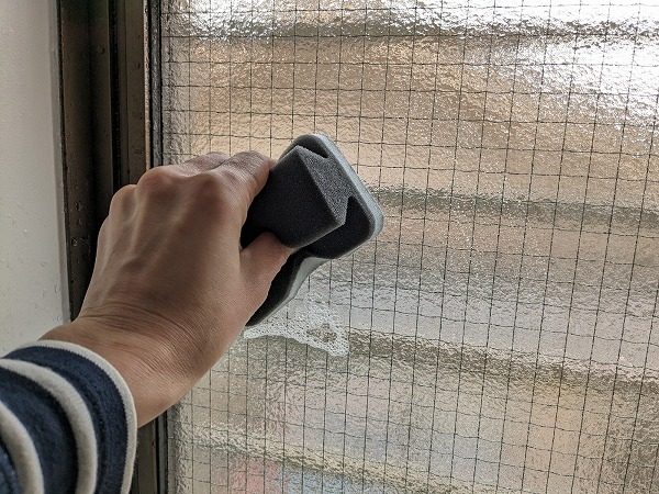 ダイソー　お掃除スポンジ（フッ素樹脂配合、窓用）で窓掃除をしている様子