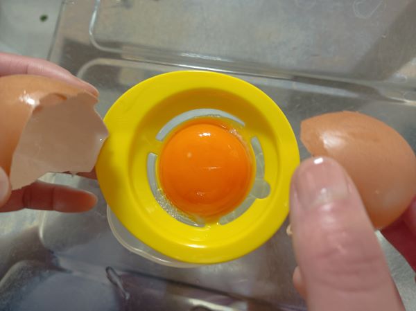 セリア「ふわふわエッグメーカー」の黄身分けの上に黄身を落とすように卵を割った図