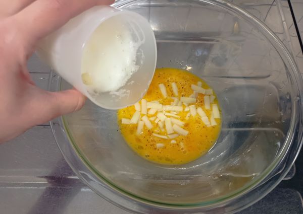 卵を割り入れたボウルにセリア「ふわふわエッグメーカー」で作ったメレンゲを入れる図