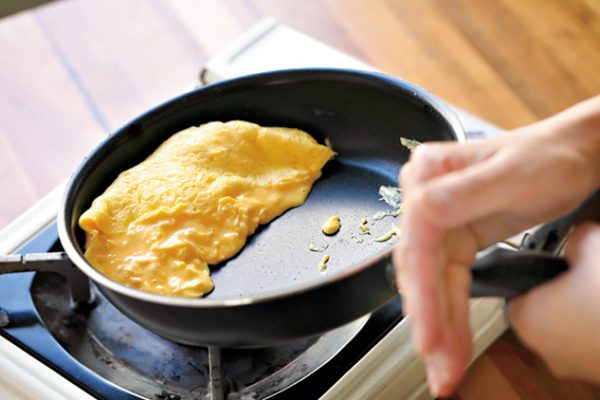 フライパンでオムライスの卵をふっくら仕上げている調理シーン