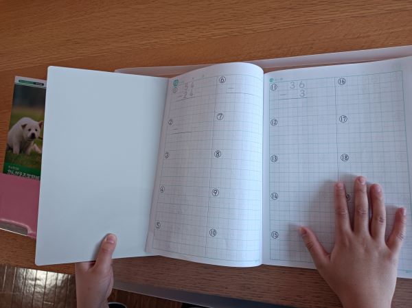 セリア「両面書きわけ下じき」の表面（ベージュ面）を計算ノートに挟む図