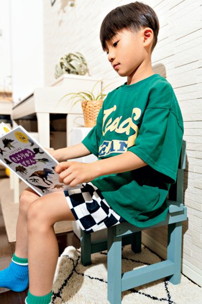 ミニチェアに座って本を読む男の子