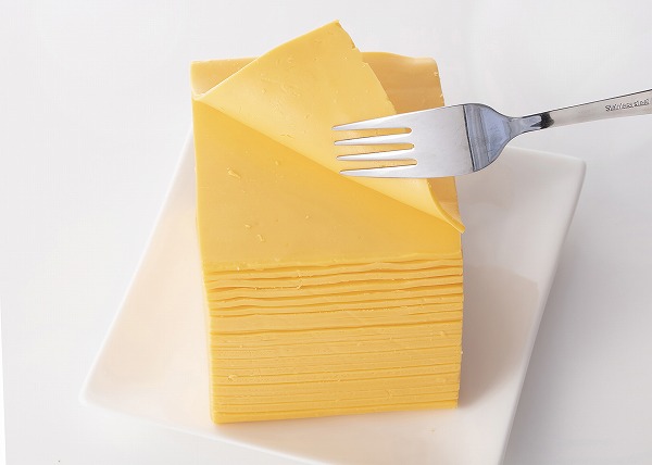 コストコ　カークランドシグネチャー アメリカンスライスチーズ 2.27kgを1枚はがしている様子