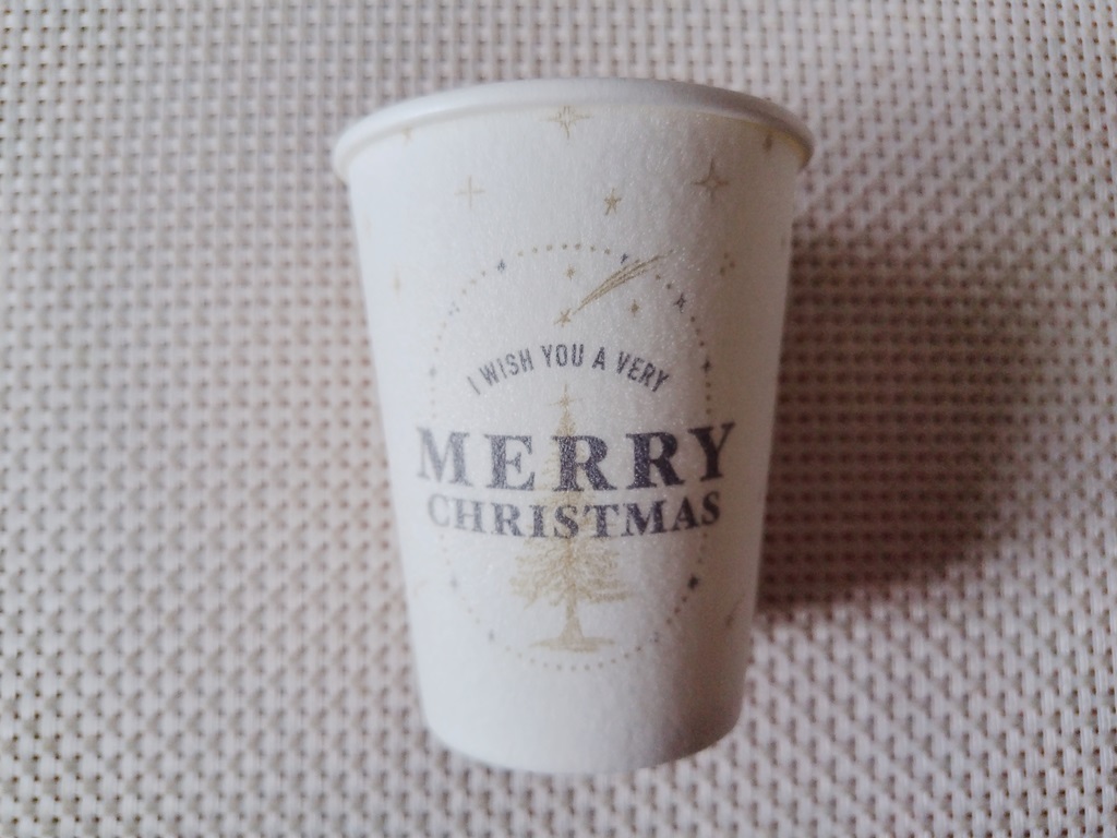 白い耐熱カップにMerry Christmasという文字とツリーと星が描かれています。