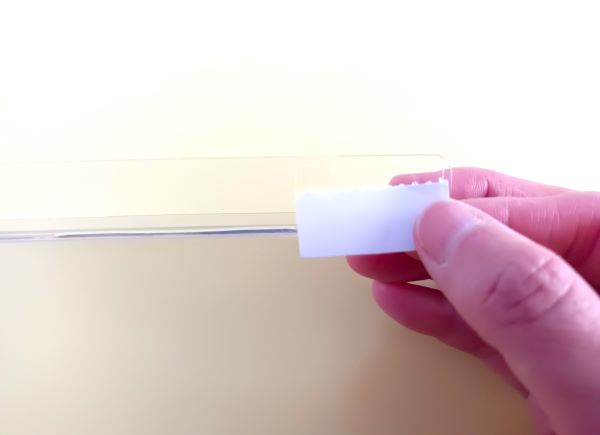 セリア「L字仕切り板」に付属の粘着テープを貼る図