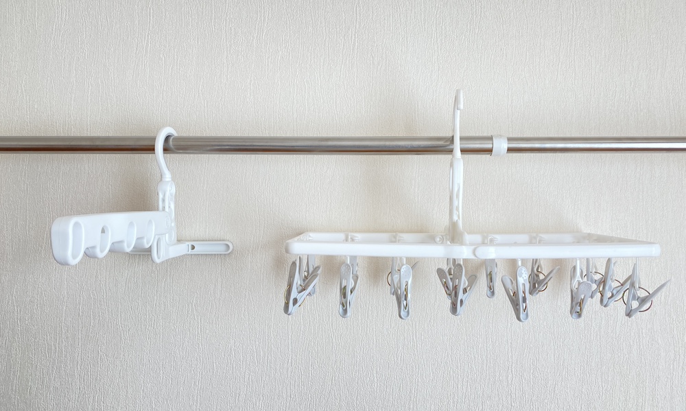 ニトリの室内干しシャツハンガー5連フック（ミル）と室内&外干し角ハンガー（16ピンチ ミル）を並べて物干し竿に掛けている様子。