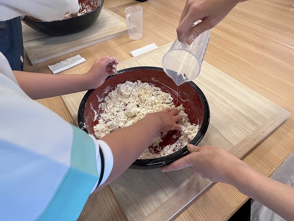 「丸亀製麺 手づくり体験教室」で振るった粉に塩水を加える