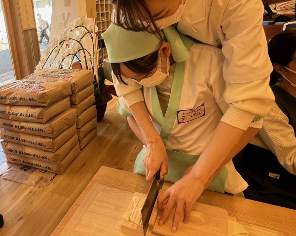 「丸亀製麺 手づくり体験教室」で麺生地を切っているところ
