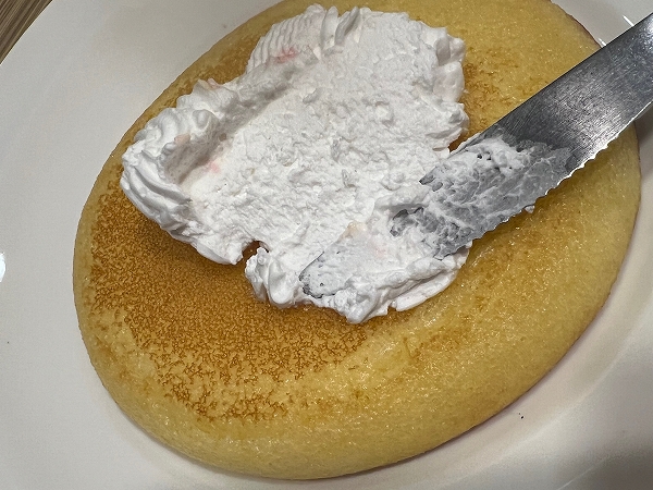 ガストの「DIY パンケーキプリンアラモード」のパンケーキにホイップを塗る